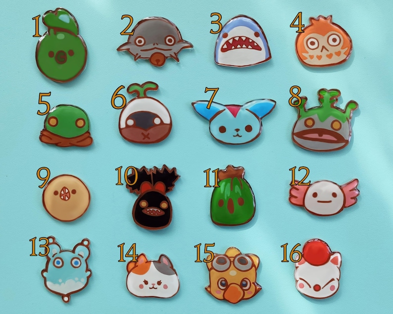 May include: Set of 16 colorful enamel pins featuring various cartoon characters. The pins are numbered 1 through 16 and feature a variety of designs, including a shark, a frog, a mushroom, a cat, and a fish.