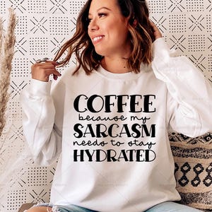 Puede incluir: Sudadera blanca de manga larga con texto negro que dice "Coffee because my sarcasm needs to stay hydrated."