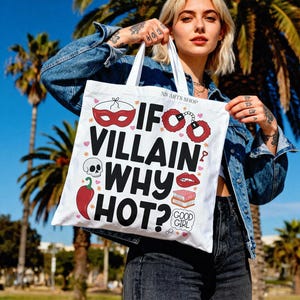 Puede incluir: Bolso tote blanco con el texto "If Villain Why Hot?" y varias ilustraciones, incluyendo una m&aacute;scara, esposas, una calavera, un chile y labios. El bolso es sostenido por una persona con una chaqueta vaquera.