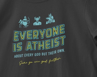 May include: Dark gray t-shirt with the text "EVERYONE IS ATHEIST" in teal and yellow. The shirt also features illustrations of mythological figures. The text below reads "ABOUT EVERY GOD BUT THEIR OWN. Some go one god further."