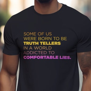 May include: Black t-shirt with the text "SOME OF US WERE BORN TO BE TRUTH TELLERS IN A WORLD ADDICTED TO COMFORTABLE LIES."