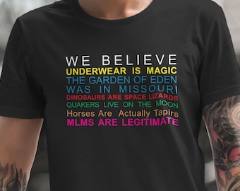 May include: Black t-shirt with a rainbow colored text design that reads "We Believe Underwear is Magic, The Garden of Eden Was in Missouri, Dinosaurs are Space Lizards, Quakers Live on the Moon, Horses are Actually Tapirs, MLMs are Legitimate."