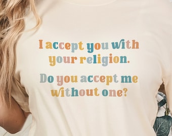 May include: A white t-shirt with the text "I accept you with your religion. Do you accept me without one?" printed in colorful letters.