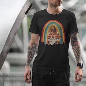 K&ouml;nnte beinhalten: Ein schwarzes T-Shirt mit einer Retro-Grafik von Jesus in einem Regenbogen mit dem Text "Jesus loves you" und "April Fools" darunter.