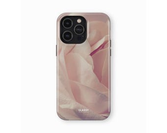May include: A phone case with a close-up image of a soft pink rose. The case has a clear back and a black border. The text "CLASSY" is printed on the bottom of the case.