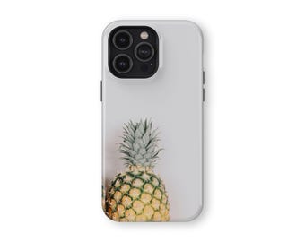 Peut inclure: Coque de téléphone blanche avec un motif ananas. L'ananas est jaune et vert et est centré sur la coque.