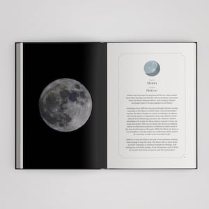 May include: An open book displaying a full-page illustration of the moon on the left side against a black background, and text about the Moon and Home on the right side, featuring a small moon icon above the title and descriptive paragraphs.