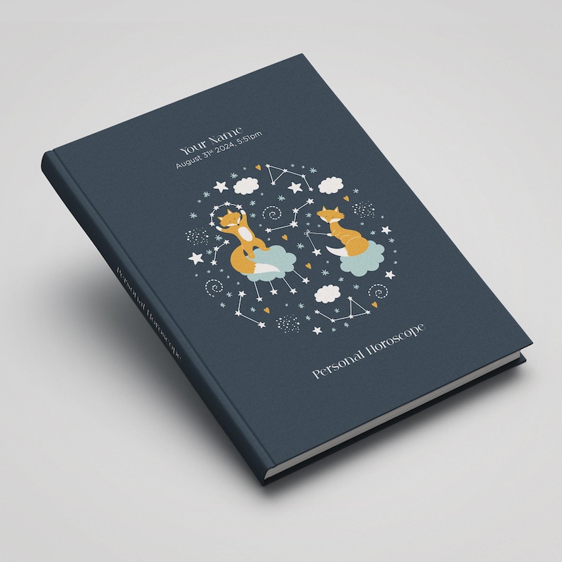 May include: A dark blue hardcover journal with a personalized name, date, and time. The cover features a whimsical illustration of two foxes on clouds surrounded by stars and constellations. The text "Personal Horoscope" is printed on the bottom of the cover.
