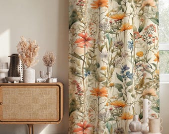 Puede incluir: Una cortina de cuerpo entero con un estampado botánico de flores silvestres naranjas, amarillas y azules sobre un fondo crema. La tela muestra ilustraciones detalladas de varios tallos, hojas y flores en un patrón vertical.