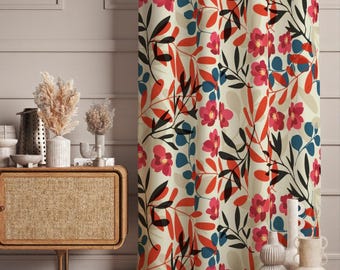May include: A floor-length curtain featuring a repeating botanical pattern of pink flowers, orange-red leaves, and dark blue foliage on a cream-coloured background. The fabric hangs in vertical folds, displaying a dense, colourful floral print.