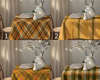 May include: Four different tablecloths with various patterns are displayed on tables. Each table is set with white plates, a white vase with flowers, and a smaller white vase. The tablecloths feature plaid and striped designs in shades of yellow, orange, and green.