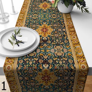 Puede incluir: Camino de mesa detallado con un diseño de alfombra persa. El camino de mesa presenta un fondo verde azulado oscuro con un patrón floral repetido en dorado, rojo y amarillo. Los bordes están bordeados con un diseño dorado y amarillo. El camino de mesa está sobre una mesa blanca.