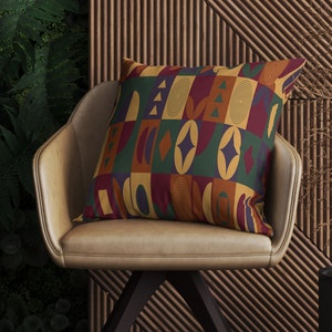 May include: A brown leather chair with a colorful geometric patterned pillow. The pillow has a mix of red, yellow, green, blue, and orange colors.
