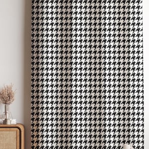 Puede incluir: Tela con estampado de pata de gallo en blanco y negro. El patrón repetitivo cubre toda la superficie, creando una textura visual audaz y clásica. La tela se utiliza probablemente para cortinas o tapicería, añadiendo un toque de sofisticación a cualquier interior.