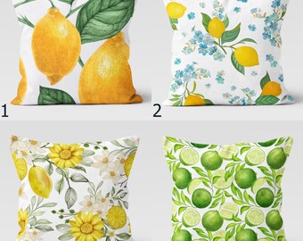 May include: Four different pillow designs featuring various patterns. The first pillow has a white background with yellow lemons and green leaves. The second pillow has a white background with blue flowers and yellow lemons. The third pillow has a white background with yellow sunflowers and green leaves. The fourth pillow has a white background with green lime slices and leaves.