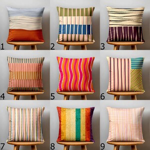 May include: A collection of nine square throw pillows featuring diverse patterns including horizontal and vertical stripes, wavy lines, and grid designs in various colour palettes such as orange, blue, pink, green, yellow, and purple.
