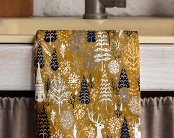 May include: A gold kitchen towel with a white deer and forest design. The towel has a white background with blue and gold accents.