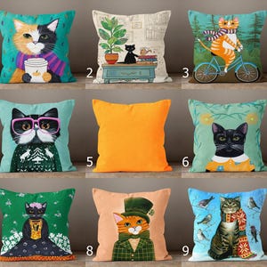This image shows a 3x3 grid of 9 decorative pillow covers, each featuring a unique cat illustration. The designs include cats holding mugs, riding bikes, wearing glasses or sweaters, surrounded by birds, or dressed in costumes. Some pillows are autumn or winter-themed, while one is a solid bright orange. All covers are colorful, whimsical, and full of personality—perfect for home decor or as a gift for cat lovers.