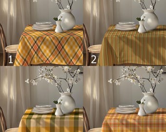 May include: Four different tablecloths with floral arrangements and white ceramic dishes. The tablecloths feature various patterns: plaid, striped, and checkered, in shades of yellow, orange, and green. Each table is set with white plates and a vase.