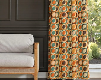 May include: A retro-style patterned curtain. The design features squares and circles in orange, brown, teal, and cream. A light-colored sofa with wooden arms is to the left of the curtain. The curtain is likely made of fabric.