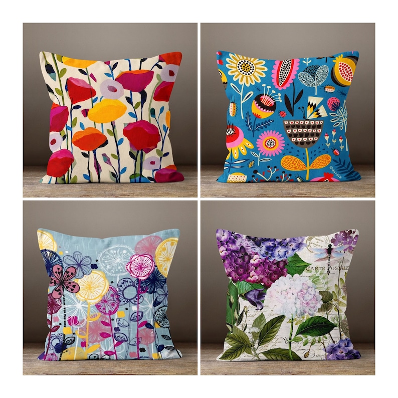 May include: Four decorative throw pillows with floral designs. The pillows feature colorful patterns of flowers in red, yellow, blue, and purple. The pillows are square-shaped and appear to be made of a soft fabric.