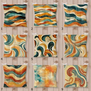 May include: A set of nine square seat cushions featuring various abstract patterns in shades of teal, orange, yellow, and cream. Each cushion is tufted with white ties at the corners and displays distinct wavy, swirling, or watercolor-inspired designs.