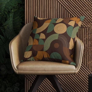 May include: A brown leather chair with a throw pillow featuring a geometric pattern in shades of brown, beige, and green. The pillow has a modern, abstract design.