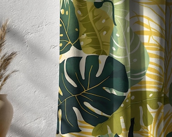 May include: Curtains with a tropical leaf pattern. The design features large, dark green monstera leaves, smaller green leaves, and yellow accents against a cream background. The fabric is draped, showing the texture and folds of the material.