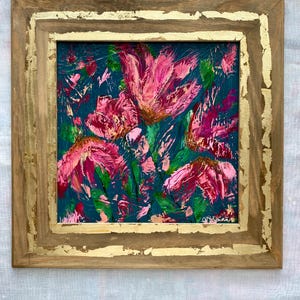 May include: Square framed floral painting with a gold leaf border. The artwork features vibrant pink flowers and green foliage against a dark teal background. The frame is a natural wood color.