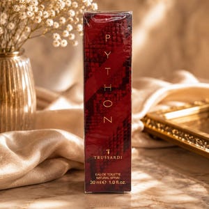 Pode incluir: Uma caixa de perfume retangular com um padrão de pele de cobra em vermelho escuro e preto. O texto diz PYTHON, TRUSSARDI, EAU DE TOILETTE, NATURAL SPRAY, 30 ml e 1.0 fl.oz. A caixa está envolvida em plástico transparente e está na vertical.