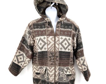 May include: A hooded jacket with a geometric pattern in shades of brown, beige, and gray. The jacket features a full zipper closure, two front pockets, and toggle closures on the hood. The jacket is displayed on a white mannequin.