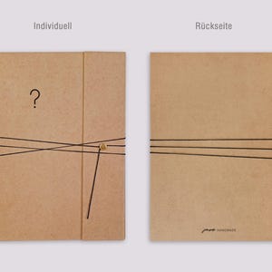 May include: Two views of a light brown rectangular folder made of thick paper. The left view shows a front cover with a question mark and a black elastic band secured by a gold button. The right view shows the back cover with a black elastic band.