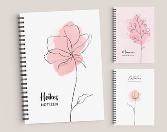 May include: Three pink and white floral notebooks with black spiral bindings. The covers feature simple line drawings of flowers with watercolor washes. The notebooks are titled "Heikes Notizen", "Memories Janine & Peter", and "Flüsterlies GedankenSammler".