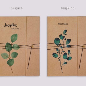 May include: Two rectangular kraft paper notebooks with black elastic closures and gold-toned fasteners. The left notebook features a green eucalyptus branch illustration and the text "Josephins Notizen". The right notebook displays a dark green floral branch and the name "Matthias".