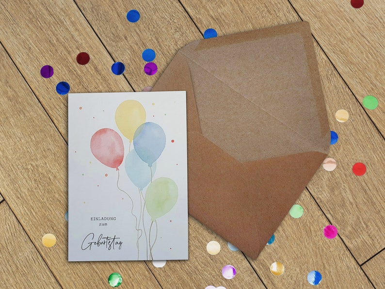 May include: A white card with a watercolor illustration of four colorful balloons. The card says "Einladung zum Geburtstag" which translates to "Invitation to Birthday" in English.