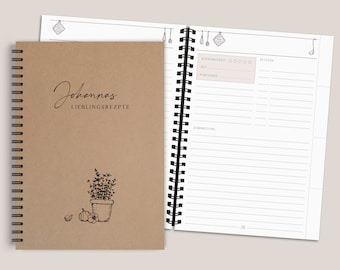 May include: A spiral-bound recipe journal with a tan cover featuring the text Johannas LIEBLINGSREPTE and a line drawing of a potted herb and garlic. The open page displays a template for recording recipe difficulty, time, portions, and ingredients.