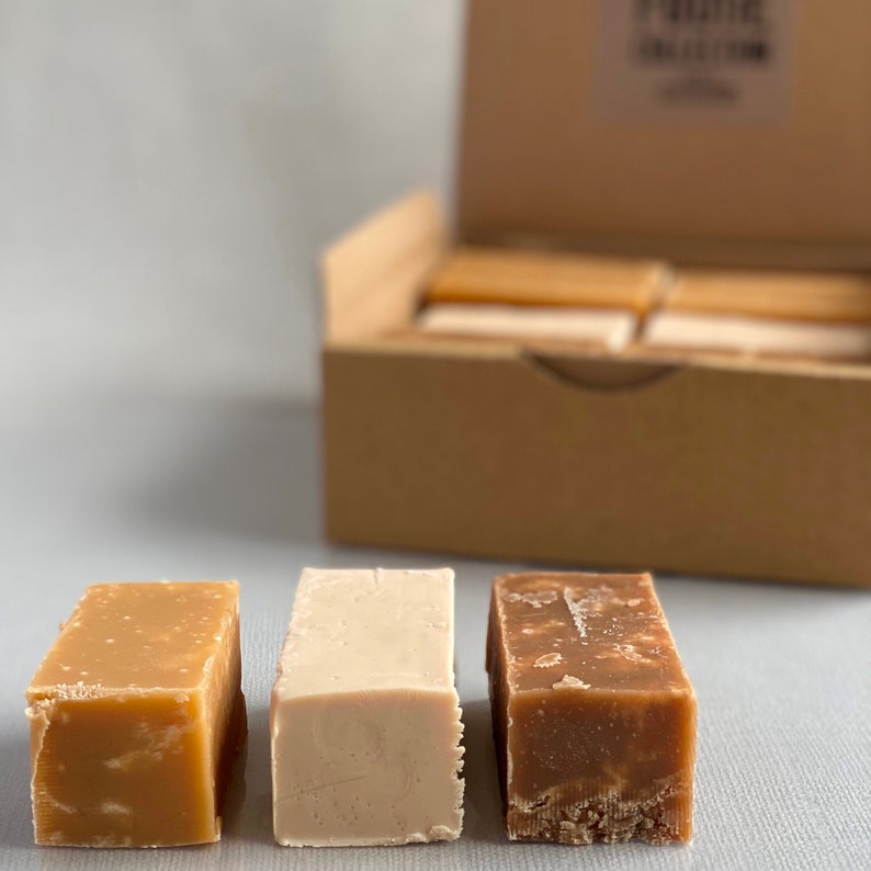 Op de afbeelding: Drie verschillende smaken fudge in een doos. De fudge is in vierkanten en is lichtbruin, wit en donkerbruin.