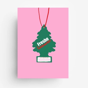 Pode incluir: Um cartão rosa com um ambientador verde em forma de árvore de Natal. O ambientador tem as palavras "Freshe" e "Tannenduft" impressas, com uma corda vermelha presa. O cartão também tem o texto "and a happy new year".