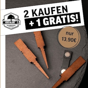 Könnte beinhalten: Drei hölzerne Stecknadeln mit einer spitzen Spitze und einem dekorativen Kopf. Die Nadeln sind in Dreiecksform auf einer dunkelgrauen Oberfläche angeordnet. Der Text "2 KAUFEN + 1 GRATIS!" befindet sich in der oberen rechten Ecke des Bildes. Der Text "nur 13,90€" befindet sich in der oberen rechten Ecke des Bildes. Der Text "ANSTECKNADELN //" befindet sich in der unteren Mitte des Bildes. Der Text "Modell "Iris"" befindet sich in der unteren Mitte des Bildes.