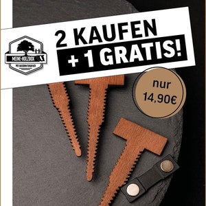 May include: Three wooden pin badges in the shape of a T with a serrated edge. The badges are brown and have a magnetic backing. The text on the image reads "2 KAUFEN + 1 GRATIS! nur 14,90€ ANSTECKNADELN // Modell "Flieder""