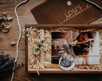 May include: A wooden box with a photo of a couple, a small bouquet of white flowers, and a tag that says "Made with Love".
