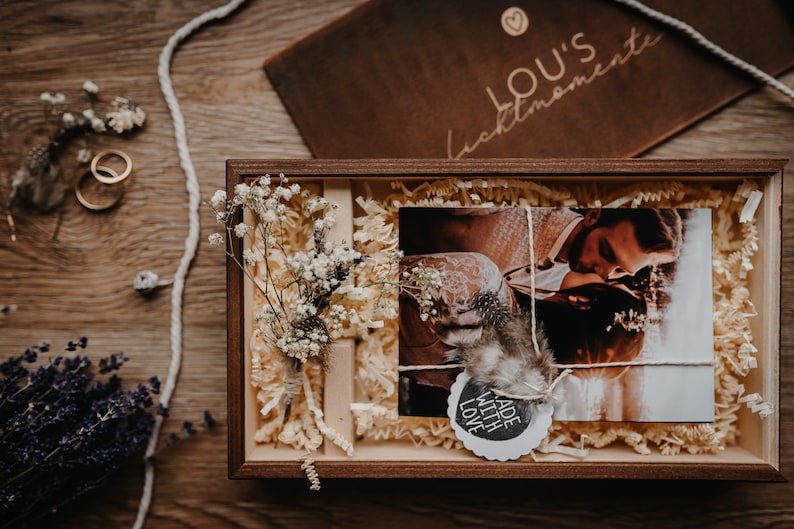 May include: A wooden box with a photo of a couple, a small bouquet of white flowers, and a tag that says "Made with Love".