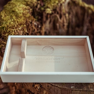May include: A white wooden box with a clear glass top. The box has a logo that says "FOTO-DREAMS" and "Kreative Bildwelten".
