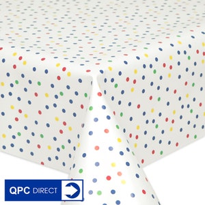 May include: White tablecloth with a colourful polka dot pattern. The dots are red, yellow, blue, and green.