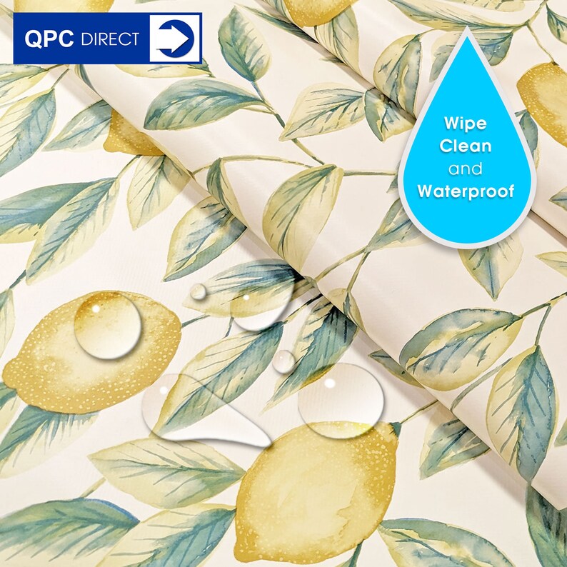 May include: A white tablecloth with a lemon and leaf pattern. The tablecloth is waterproof and can be wiped clean. The tablecloth is shown with water droplets on it.