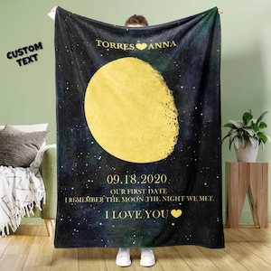 May include: A black fleece blanket with a gold moon and stars design. The text "TORRES ANNA" and "09.18.2020 OUR FIRST DATE I REMEMBER THE MOON THE NIGHT WE MET. I LOVE YOU" is printed on the blanket.