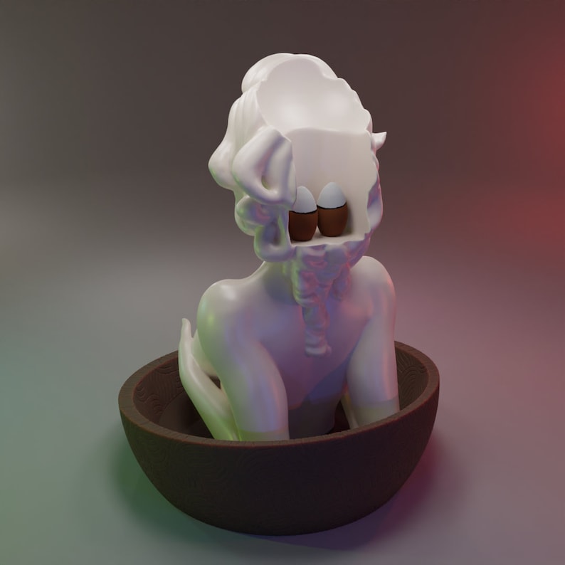 May include: A white ceramic sculpture of a person with their head open, revealing two eggs inside. The sculpture is sitting in a brown bowl.