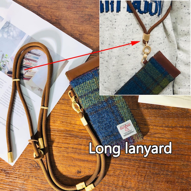 May include: A long, brown lanyard with gold-colored metal accents and a matching case. The case is made of blue and green plaid fabric with a brown leather top. The text "Long lanyard" is visible.