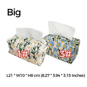 May include: Two tissue box covers with floral embroidery. The cover on the left has white flowers on a beige background. The cover on the right has blue flowers on a beige background. Both covers are labeled with numbers, "1#" and "3#" respectively. The covers measure 8.27 inches long, 3.94 inches wide, and 3.15 inches high.