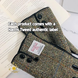 Op de afbeelding: Close-up van een paar vingerloze handschoenen van bruin en groen tweed met zwarte leren afwerking en zwarte knopen. De handschoenen hebben een label met de tekst "Harris Tweed" met daaronder de woorden "Outer Hebrides of Scotland". De tekst "Each product comes with a Harris Tweed authentic label" is over de afbeelding gelegd.